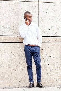 young successfil african businessman with mobilephone talking walking outdoor