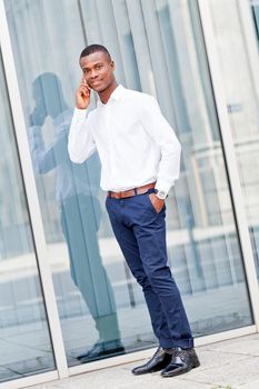 young successfil african businessman with mobilephone talking walking outdoor
