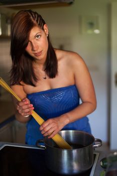 happy woman cooking spaghetti