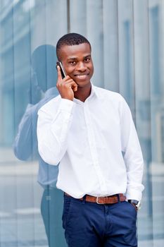 young successfil african businessman with mobilephone talking walking outdoor