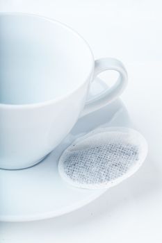 Closeup view of empty cup and teabag on a plate