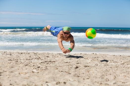 attractive adult man playing beach volleyball in summer holiday vacation