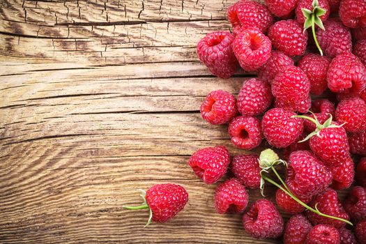 Raspberries on wooden table background with copy space. Top view
