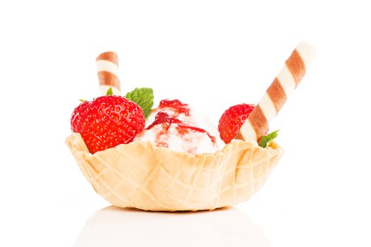 vanilla ice cream with strawberries with waffle sticks and red sauce in a waffle cup on white
