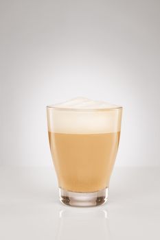 small cappuccino in a glass cup on gray background