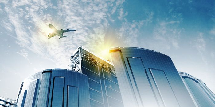 Plane flying above skyscrapers. Business travel concept