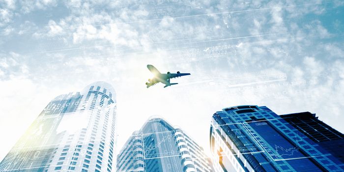 Plane flying above skyscrapers. Business travel concept