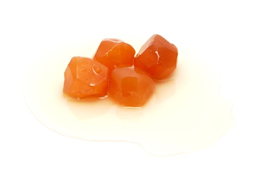 Four pieces of preserved ginger in sweet syrup, isolated on a white background