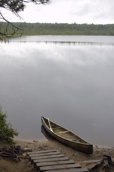 Lake and canoe before portage in rainy day in Algonquin Park