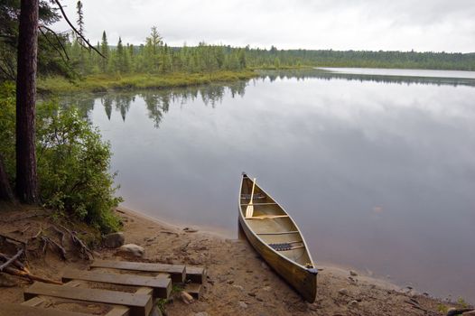 Lake and canoe before portage in rainy day in Algonquin Park