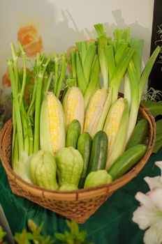 a basket of vegetables, sweet corn, bitter gorud and scallion