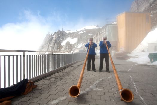 LUCERN, SWITZERLAND - APRIL 10 : Unidentified musicians are playing music with Alpine horns at Pilatus Mountain in Lucern Switzerland on April 10, 2010.