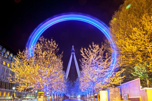 LONDON - April 15: Trees lead to the London Eye, on April 15, 2012 in London. The largest Ferris wheel in Europe, structure of the London Eye is 135 M. tall and the wheel has a diameter of 120 M.