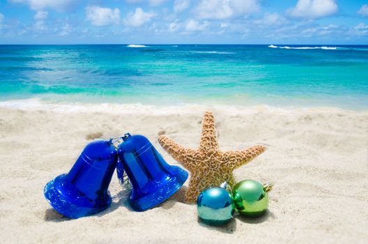 Starfish with Christmas decoration on sandy beach in sunny day- holiday concept