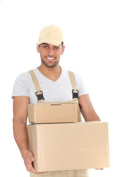 Handsome man delivering packages in plain unlabelled brown cardboard boxes he is carrying in his hands, isolated on white