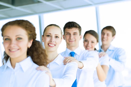 portrait of a young business woman standing in line with colleagues, concept of teamwork