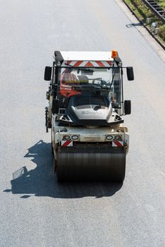 STUTTGART, GERMANY - AUGUST 10,2013: Workers laying asphalt on a public interstate (B27) during holiday season on August 10, 2013 in Stuttgart, Germany.