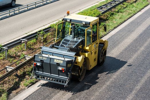 STUTTGART, GERMANY - AUGUST 10,2013: Workers laying asphalt on a public interstate (B27) during holiday season on August 10, 2013 in Stuttgart, Germany.