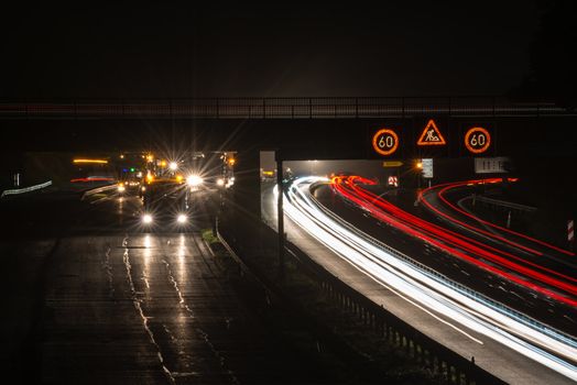 STUTTGART, GERMANY - AUGUST 16 ,2013: Workers removing asphalt on a public interstate (B27) using heavy machinery during holiday season on the evening of August 16, 2013 in Stuttgart, Germany.