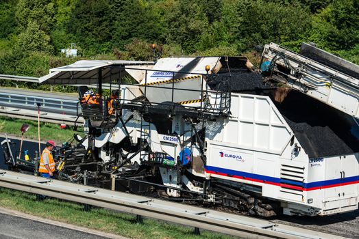 STUTTGART, GERMANY - AUGUST 17,2013: Workers laying asphalt on a public interstate (B27) using heavy machinery during holiday season on August 17, 2013 in Stuttgart, Germany.