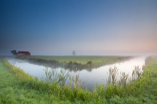calm summer misty morning over river, Groningen, Netherlands