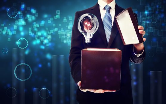 Business man opening box with an idea lightbulb on blue technology background