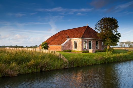 charming farmhouse by river in sunlight