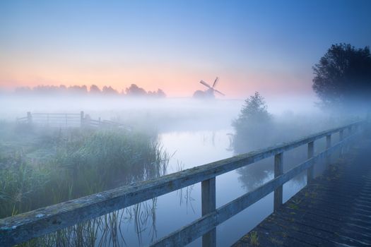 view on windmill ib fog from bridge over river, Holland