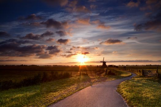 warm sunbeams by Dutch windmill at sunrise, Groningen, Holland