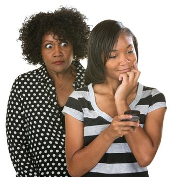 Overprotective mother with teenage daughter reading text messages