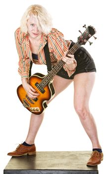 Happy young woman playing guitar and dancing