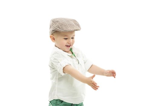 Laughing youngster wearing a cute cloth cap holding out his hands as though reaching for something, upper body portrait isolated on white