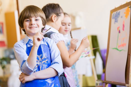 Little children painting and playing at kindergarten