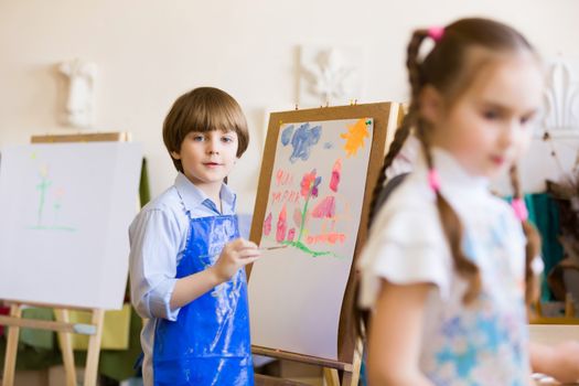 Little children painting and playing at kindergarten