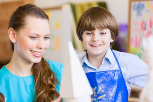 Young teacher and children painting and playing