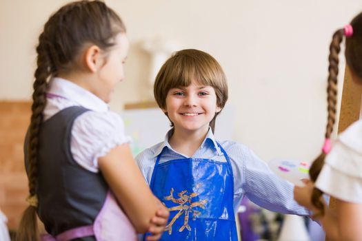 Little children painting and playing at kindergarten