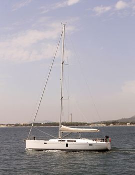 Side view of white yacht sailing on ocean.