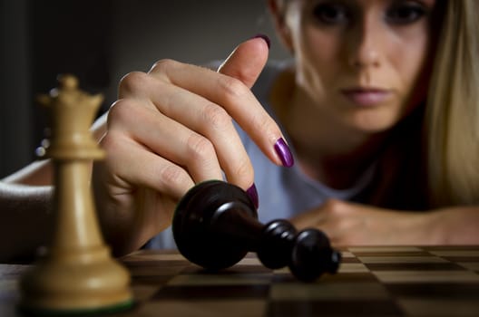 woman surrendering her king after loosing a game of chess