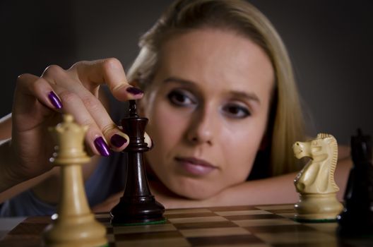 woman playing chess making her move with focus on the chess piece