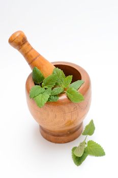 wooden mortar with melissa leaves