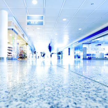 Passengers walking in contemporary hallway of airport