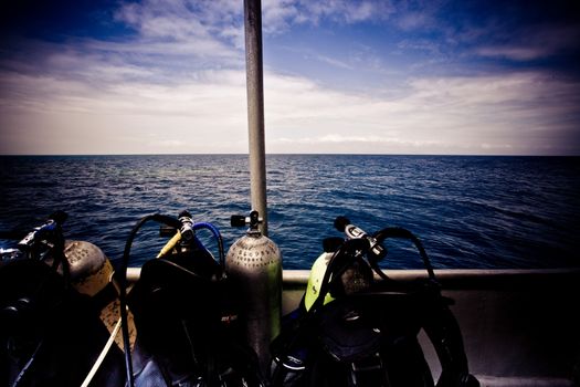 Scuba equipment standing ready on the deck of a dive boat out in mid ocean