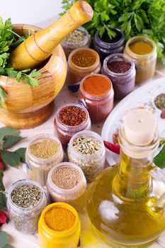 Mix of fresh herbs, spices and oil with mortar on the table