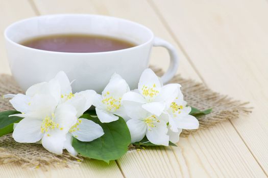 Cup of jasmine tea and jasmine flowers