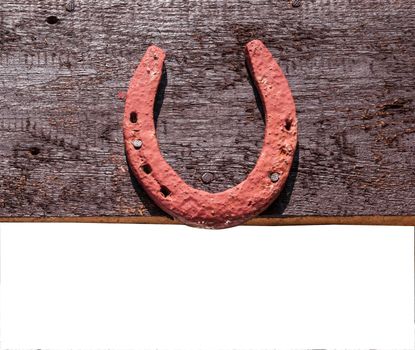 The old horseshoe hanging on wooden wall on a white background