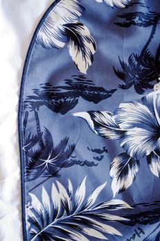 shorts bathing trunks background with blue white topical flowers and palms background closeup.