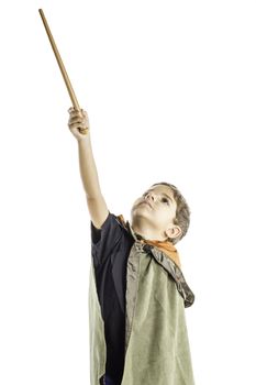 A young boy dressed in a wizard costume holding a wand isolated on a white background.