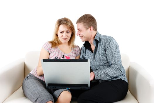 Young woman and a man with a laptop sitting on the couch
