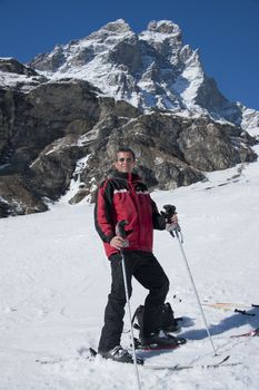 man staying on the ski, on a slope under the Matterhorn