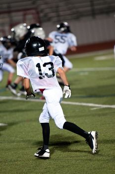 Youth american football boy playing defense watching the ball.